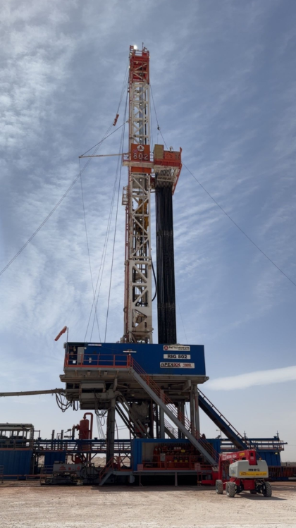 A tall oil drilling rig under a partly cloudy sky. A tall oil drilling rig under a partly cloudy sky.