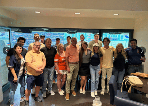 A group of people smiling and posing together indoors. A group of people smiling and posing together indoors.